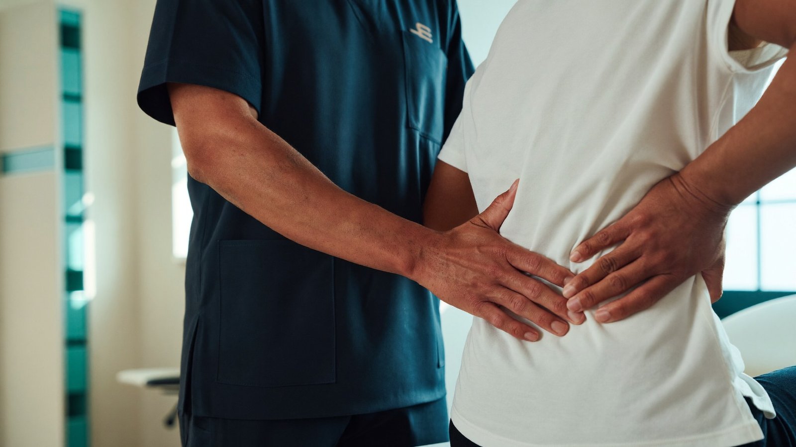 Fisioterapeuta realizando terapia manual na coluna de uma paciente na clínica Checkup Fisio