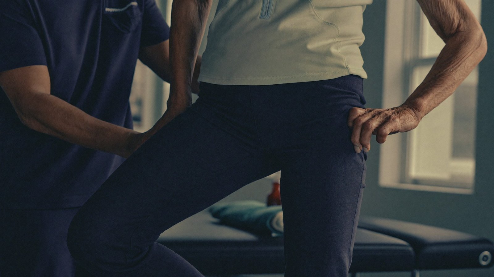 Fisioterapeuta orientando exercício de equilíbrio para prevenção de quedas com uma paciente idosa na clínica Checkup Fisio