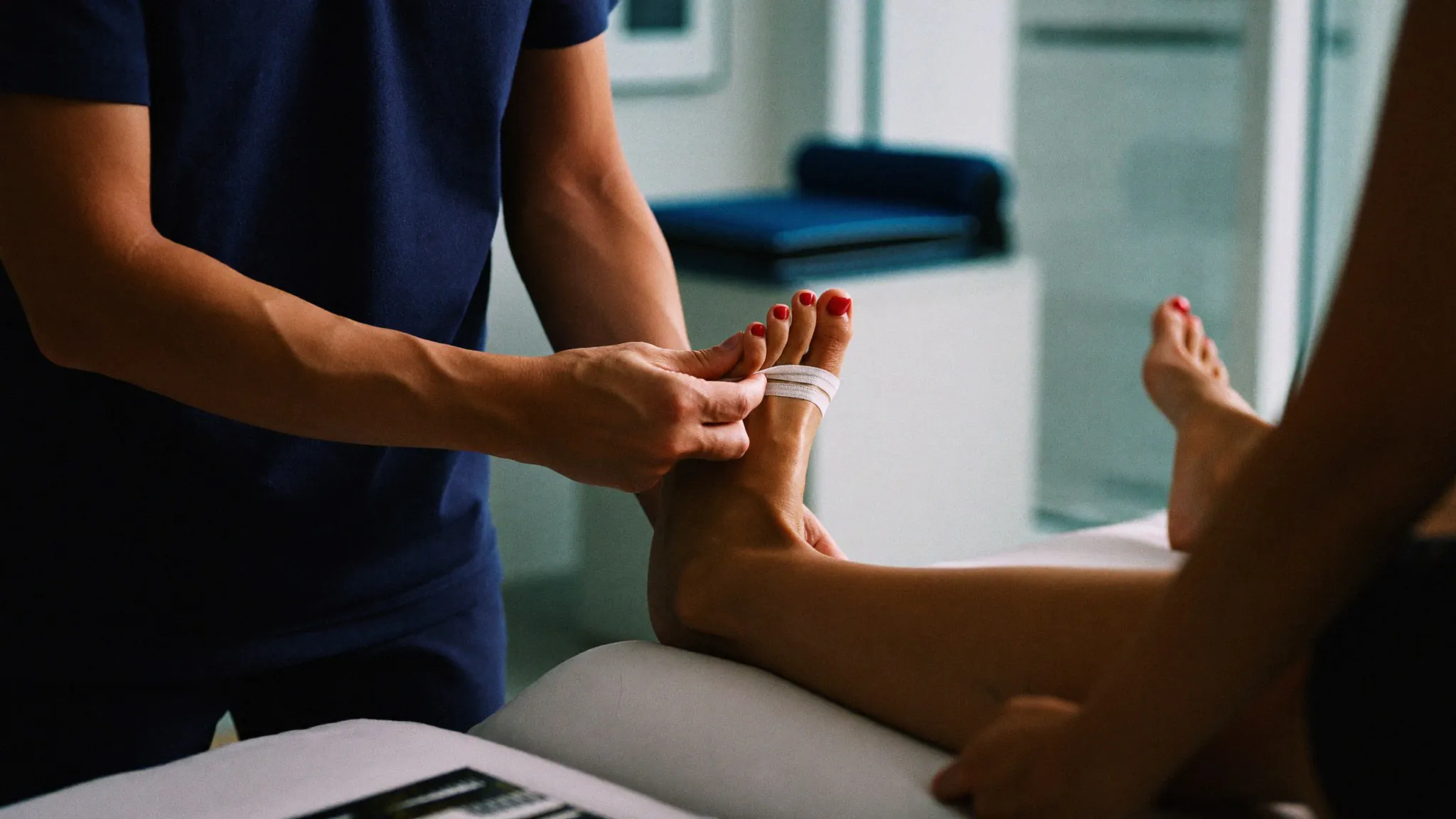 Fisioterapeuta realizando terapia manual no tornozelo de uma paciente na clínica Checkup Fisio